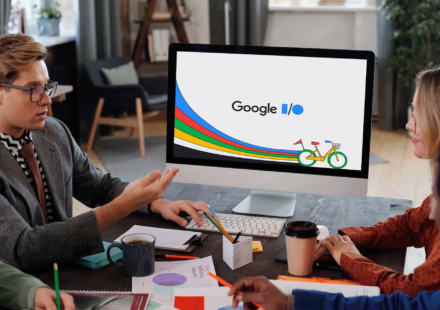 group of people speaking and a computer screen with the google io 2023 logo on it